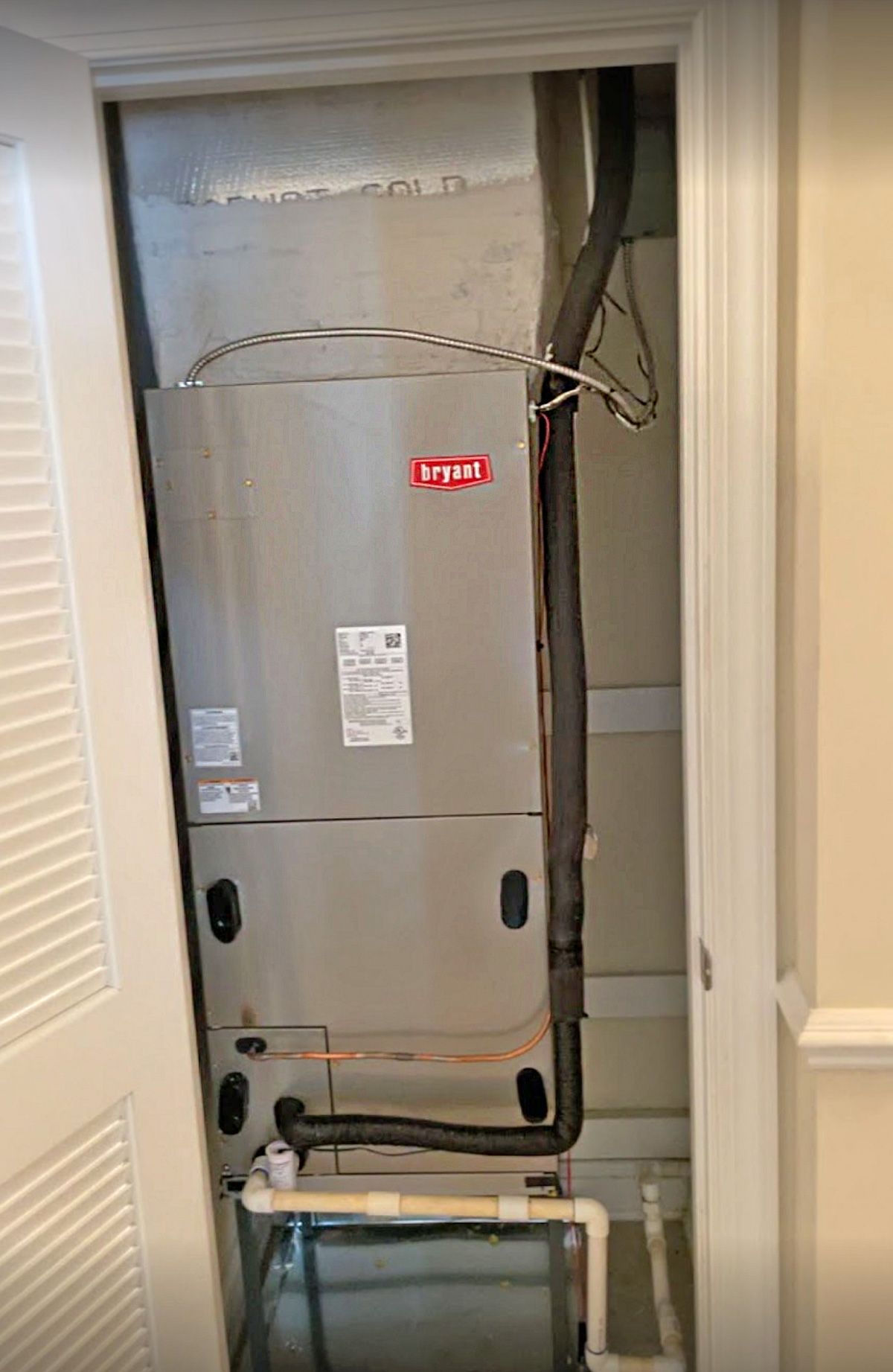 Air handler (Bryant badge) installed in a hallway closet