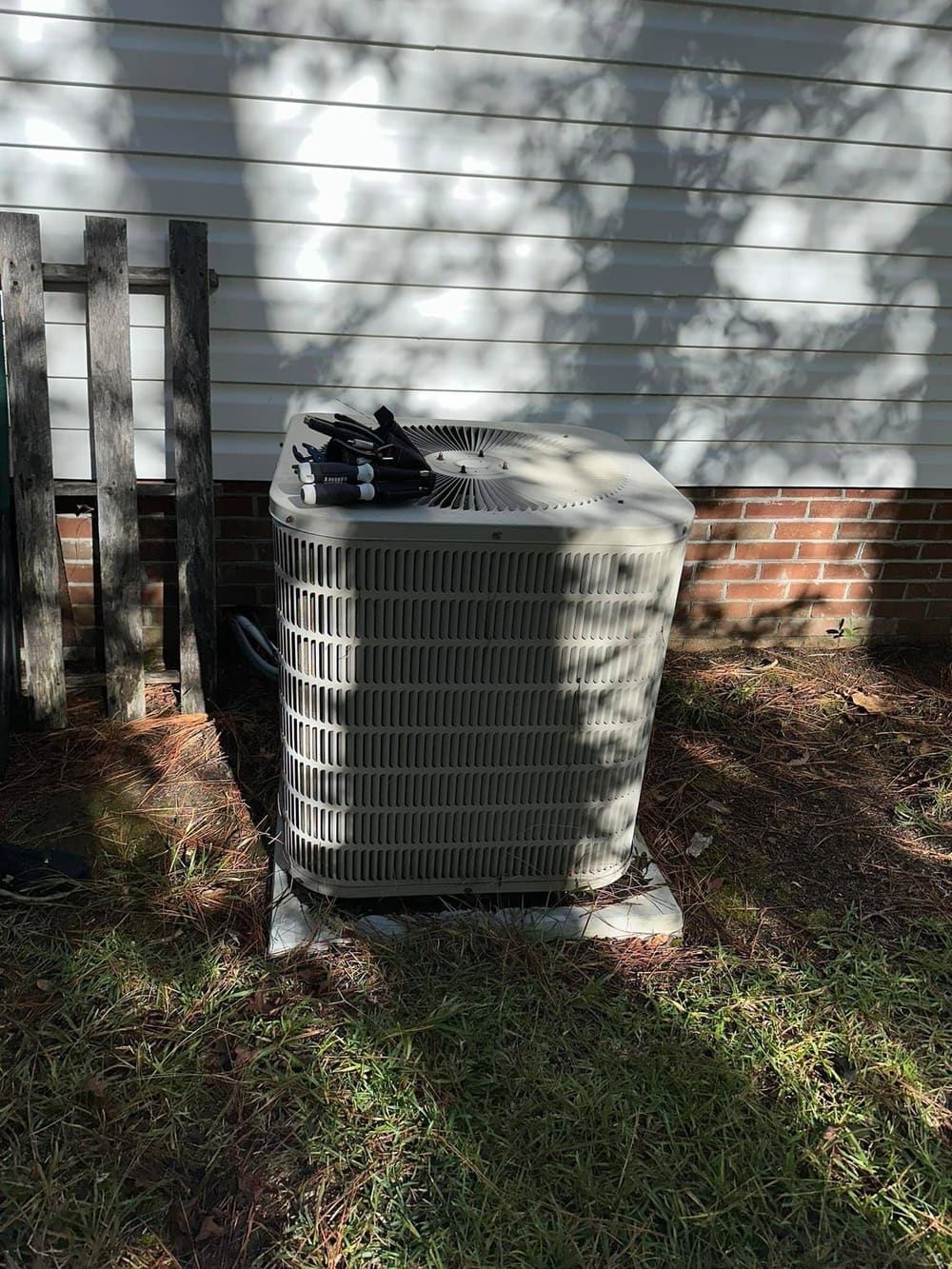 New outdoor condenser set beside a vinyl-sided house
