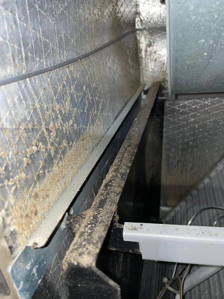 Inside an air handler plenum with dust along the sheet metal